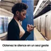 A woman on a subway platform using her phone and wearing earbuds. Podgląd zdjęcia produktu