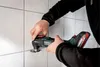 A person is using a Metabo multitool to cut grout between tiles. Náhľad obrázku produktu