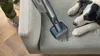 A person vacuums a couch with a dog lying on it. Náhľad obrázku produktu