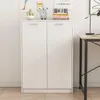 A white two-door cabinet is shown against a white wall with some decorative items on top. Podgląd zdjęcia produktu