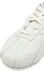 A close-up view of the toe and laces of a white sneaker. Produktbild-Vorschau