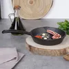 A cast iron frying pan with food ingredients on a wooden board. Produktbild-Vorschau