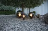 Three globe-shaped outdoor lights are placed on a gravel path in front of a white building and under a tree. Produktbild-Vorschau
