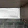 A top-down view of a bathtub with a glass shower screen in front of it, set against a tiled wall. Produktbild-Vorschau