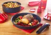 A table setting with cooked food in pans and serving dishes, along with kitchen accessories. Náhled obrázku produktu