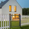 A modern house with a garden gate and fence in the evening. Produktbild-Vorschau