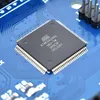 A close-up of a black microcontroller chip on a blue circuit board. Anteprima dell’immagine prodotto