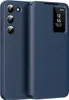 A blue leather flip case for a Samsung Galaxy S23 phone is shown with the flip cover partially open, revealing the phone's camera array and a small display window on the cover showing time and date. Náhled obrázku produktu