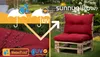 A red cushion on a wooden pallet chair in a garden setting, with marketing overlays highlighting waterproof and UV protection. Produktbild-Vorschau