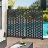 Two black decorative screens with a geometric pattern are set up on a wooden deck next to a swimming pool. Náhľad obrázku produktu