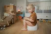 A young boy sits on a potty in a child's room. Produktbild-Vorschau