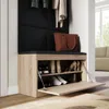 A shoe cabinet with a bench seat in a hallway or entryway, with coats hanging above and a handbag on the seat. Produktbild-Vorschau