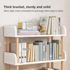 A white shelf unit with wooden legs, filled with books and a small radio. Produktbild-Vorschau