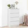 A white dresser with four drawers is shown in a room with a lamp and framed pictures on top. Anteprima dell’immagine prodotto