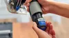 A person is holding a Dremel battery and attaching it to a Dremel tool. Produktbild-Vorschau