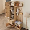 A wooden shoe cabinet with multiple shelves, drawers, and a bench, filled with shoes and accessories, set in a room. Voir les images du produit