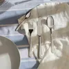 A set of cutlery laid out on a striped tablecloth and a white cloth. Produktbild-Vorschau