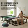 A woman is sitting on a cream-colored bench in a living room setting, with other benches in different colors behind her. Náhled obrázku produktu