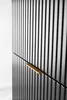 A close-up view of a black cabinet with vertical ribbed detailing and a gold handle. Anteprima dell’immagine prodotto