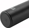 A close-up view of the bottom of a black thermos with a logo. Podgląd zdjęcia produktu