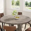 A round dining table with chairs in a well-lit room with large windows overlooking a green landscape. Anteprima dell’immagine prodotto