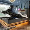 A modern bedroom with a large bed featuring an open storage compartment and LED lighting. Produktbild-Vorschau