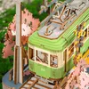 A close-up view of a wooden model train station with cherry blossom trees. Produktbild-Vorschau