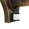 Close-up of a motion sensor attached to an outdoor wall light fixture. Produktbild-Vorschau