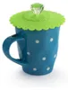 A blue polka dot mug with a green silicone lid and a clear diamond-shaped knob. Produktbild-Vorschau