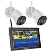 Two white security cameras are mounted on white circular bases with antennas, positioned above a black monitor displaying a split screen of a backyard scene and a swimming pool. The monitor has the brand name 'SecuFirst' at the bottom. Anteprima dell’immagine prodotto