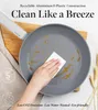 A hand is cleaning a gray frying pan with oil in it, with text overlays about the product's features. Podgląd zdjęcia produktu