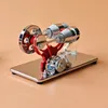 A model of a Stirling engine with a flywheel and two cylinders sits on a reflective base. Náhľad obrázku produktu