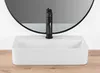 A white rectangular basin sink with a black faucet is shown in front of a large round mirror and a white wall, with a wooden surface below. Podgląd zdjęcia produktu