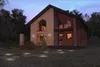 A modern house at dusk with outdoor lighting illuminating the lawn and pathway. Produktbild-Vorschau