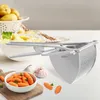 A potato masher is shown on a table with ingredients for mashed potatoes, including potatoes, carrots, and garlic. Anteprima dell’immagine prodotto