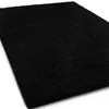 A black shaggy rug shown from a diagonal angle on a white background. Náhled obrázku produktu