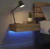 A modern bedroom setting with a floating nightstand next to a bed. Produktbild-Vorschau