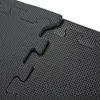 A close-up view of interlocking black puzzle mats. Voir les images du produit