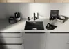 A modern kitchen sink area with a black sink and faucet, along with various kitchen accessories. Produktbild-Vorschau