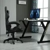 A gaming chair and desk setup in a room with a window and curtains. Produktbild-Vorschau
