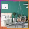 A bedroom with a bed, a hanging chair, and plants. Voir les images du produit
