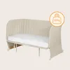 A beige convertible baby bed/sofa with a white mattress and a weight limit indicator. Produktbild-Vorschau