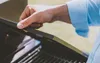 A person's hand is shown opening the lid of a grill. Produktbild-Vorschau