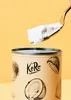 A close-up shot of a can of coconut milk with a spoon scooping some out, against a yellow background. Produktbild-Vorschau