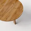 A close-up, top-down view of a round wooden coffee table with a visible wood grain and a single leg. Voir les images du produit