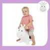 A young child is happily riding a white inflatable cow toy. Anteprima dell’immagine prodotto