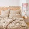 A neatly made bed with taupe musselin bedding and two woven headboards. Produktbild-Vorschau