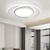 A modern white ceiling lamp with a circular design is mounted on a white ceiling. Produktbild-Vorschau