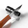 A knife is shown cutting a black tube on a white surface. Produktbild-Vorschau