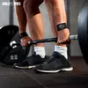 A person is lifting weights in a gym, wearing wrist wraps. Produktbild-Vorschau